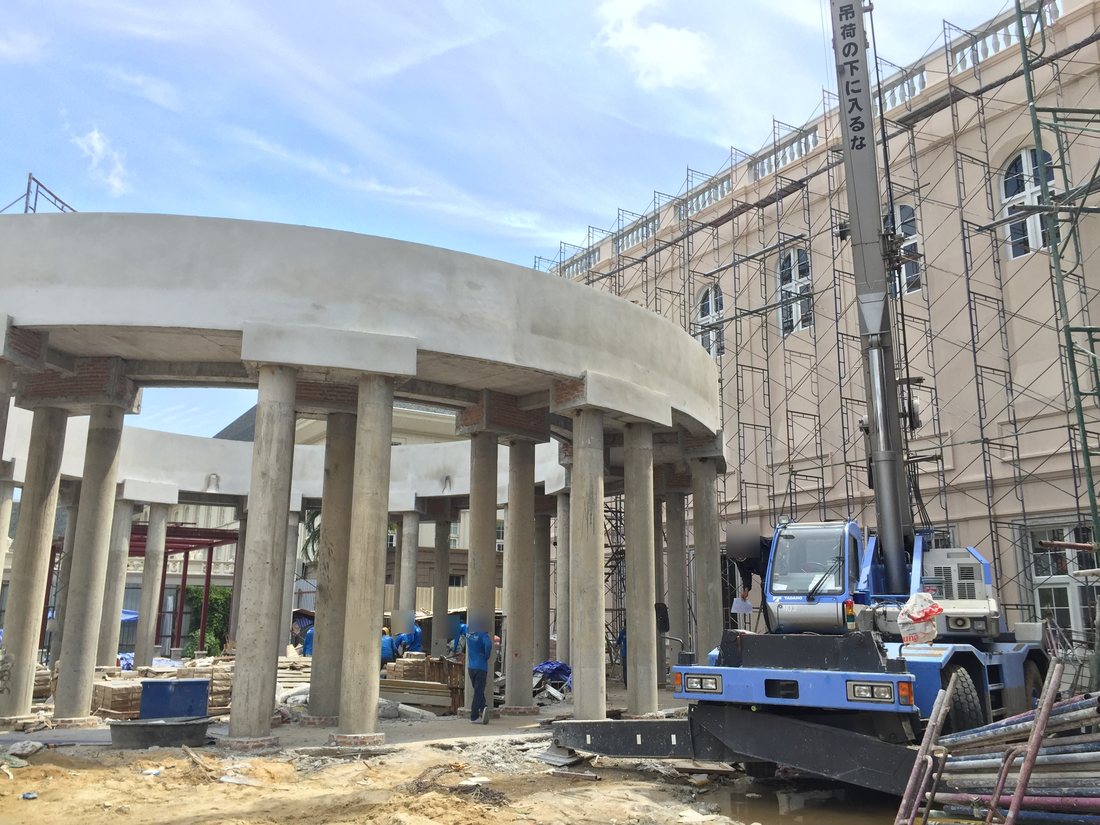 เครนล้อยาง BIG MACHINE TRADING ทำงานหน้าอาคารทรงโค้งที่ก่อสร้างใกล้เสร็จ โรงเรียนนานาชาติบางนา