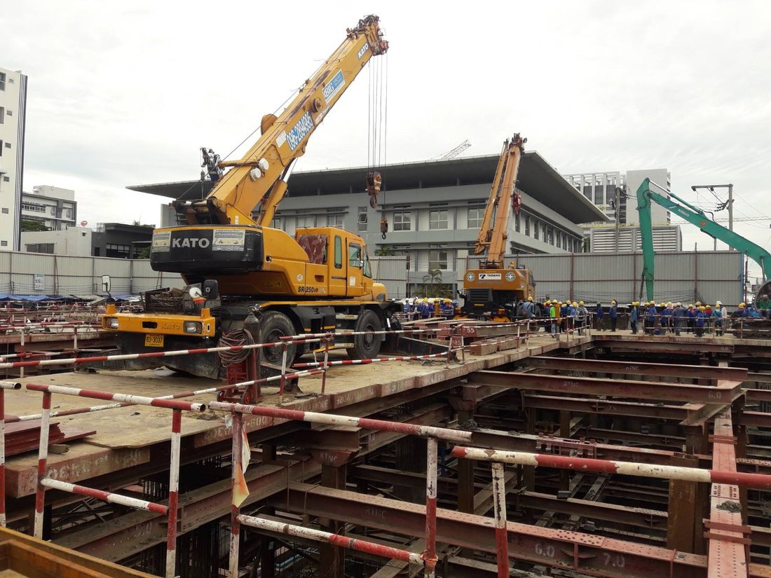 เครนล้อยาง KATO ของ BIG MACHINE TRADING ทำงานบนแท่นเหล็กที่ไซต์งานแจ้งวัฒนะ เห็นทีมงานจำนวนมากและเครนอีกคันด้านหลัง
