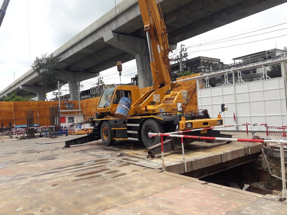 เครนล้อยาง KATO ของ BIG MACHINE TRADING ทำงานใต้ทางยกระดับในเวลากลางวันที่ไซต์งานแจ้งวัฒนะ