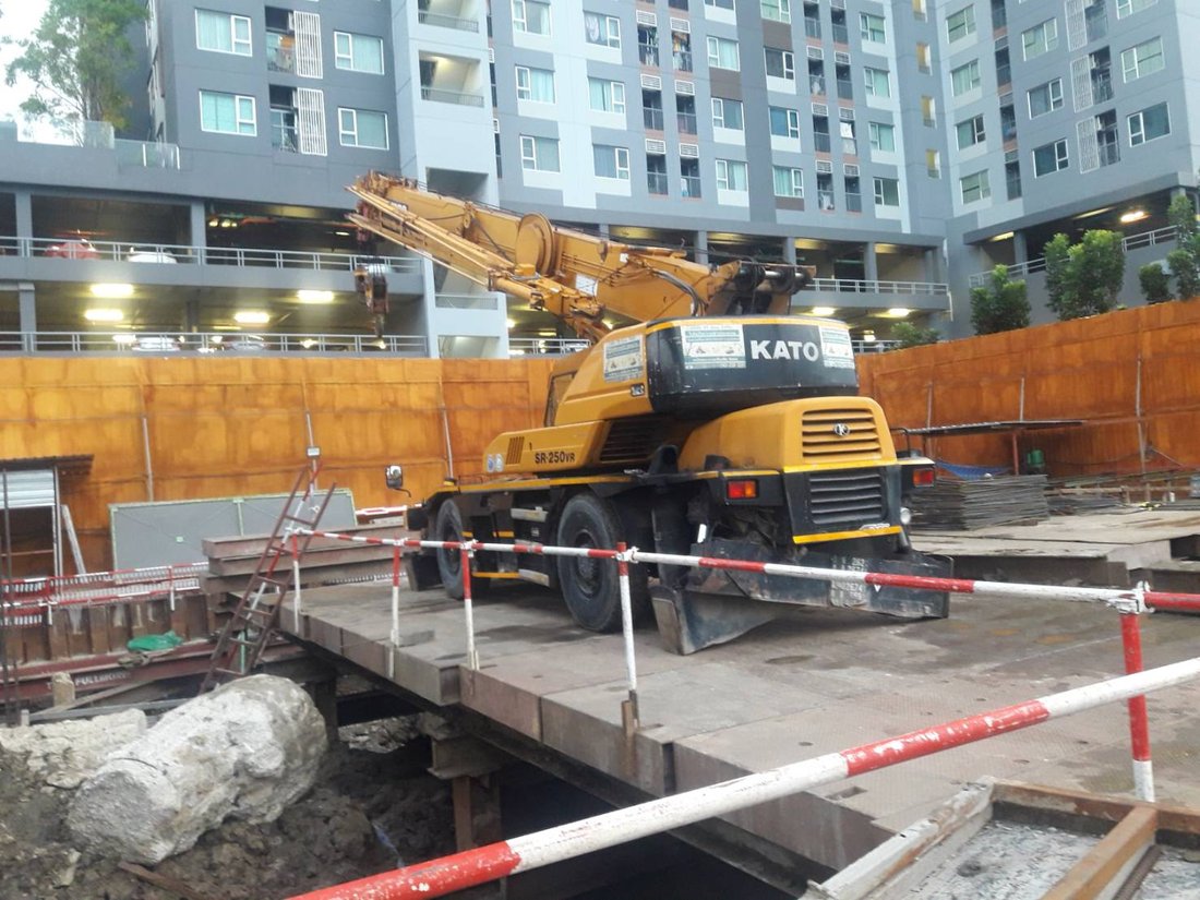 เครนล้อยาง KATO ของ BIG MACHINE TRADING ทำงานบนแท่นเหล็กที่ไซต์งานแจ้งวัฒนะ เห็นอาคารคอนโดมิเนียมสูงด้านหลัง