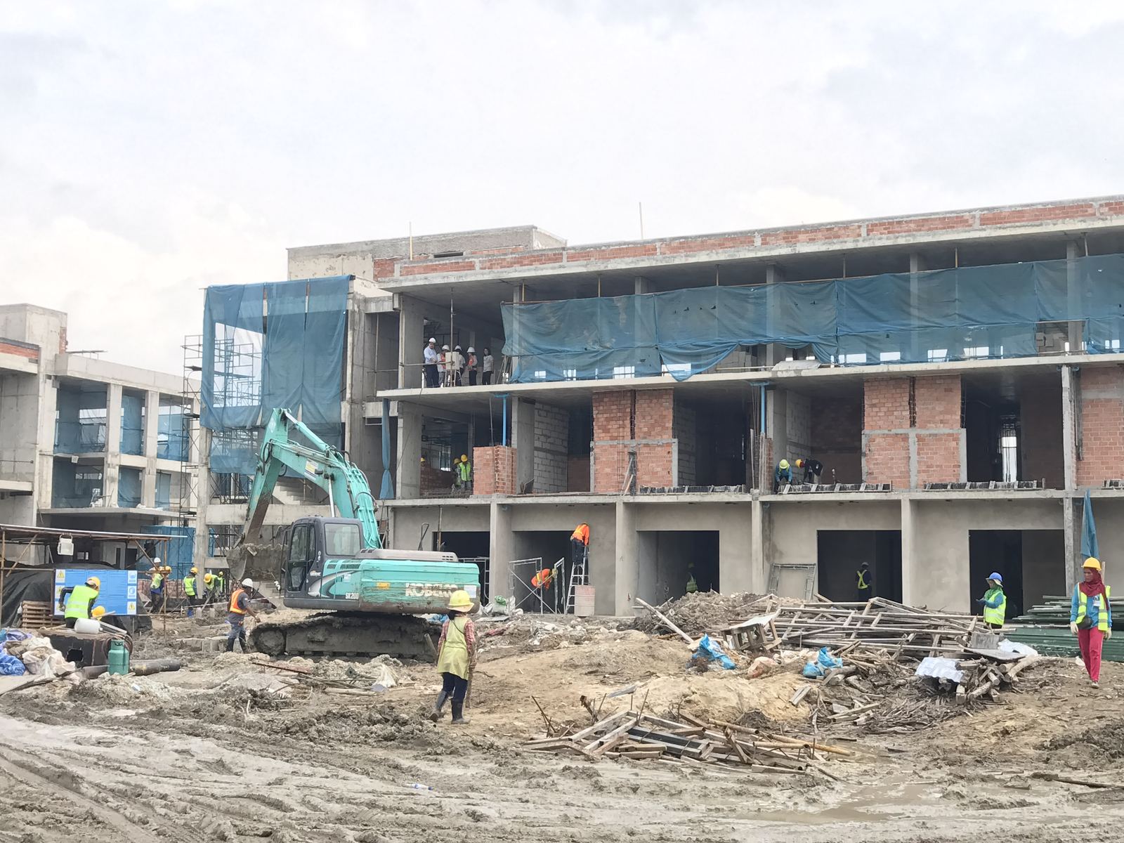แบคโฮ KOBELCO ทำงานหน้างานก่อสร้าง Eastin Thana City Golf Resort อาคารกำลังก่อสร้างอยู่ด้านหลัง