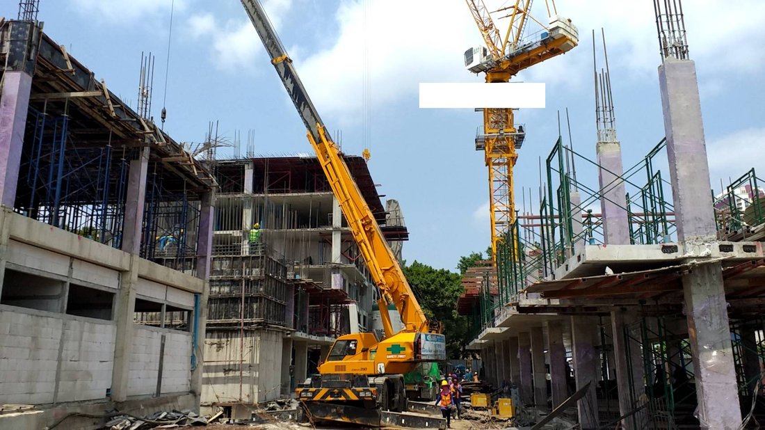 เครนล้อยาง BIG MACHINE TRADING ทำงานควบคู่กับทาวเวอร์เครนที่ไซต์ก่อสร้างกองกำกับการ 1 กองบังคับการตำรวจน้ำ เห็นโครงสร้างอาคารคอนกรีตหลายชั้น
