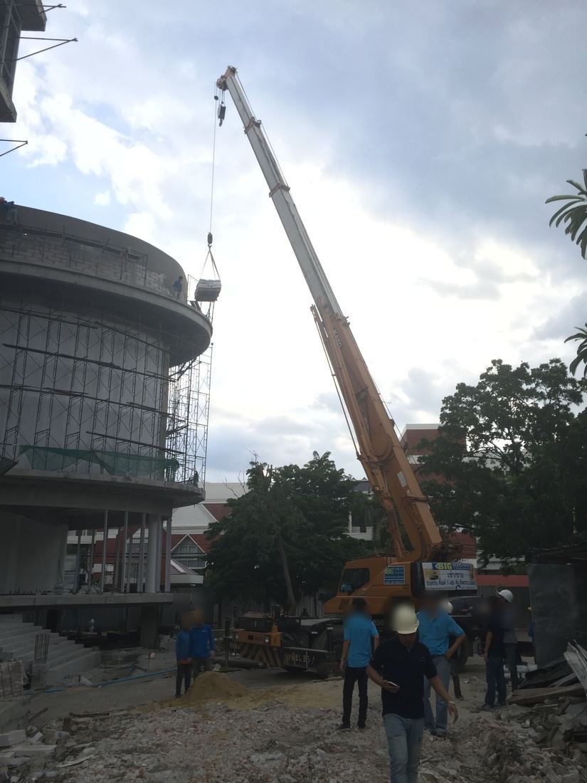 ทีมงาน BIG MACHINE TRADING และเครนตีนตะขาบทำงานหน้าอาคารทรงกลมมหาวิทยาลัยรังสิตที่กำลังก่อสร้าง