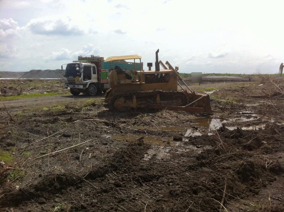 รถดันดิน CAT D6 ทำงานปรับพื้นที่ดินโคลนในโครงการพัฒนาสนามบินสุวรรณภูมิ ระยะที่ 2 พร้อมรถบรรทุกอีซูซุ