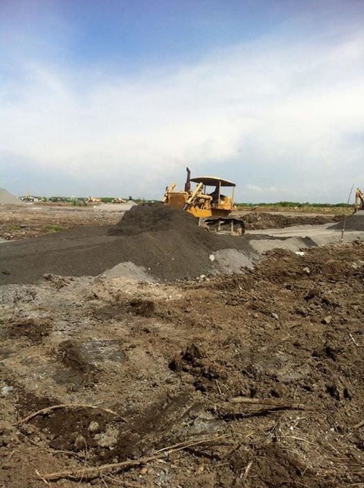 รถดันดิน CAT D6 ของ BIG MACHINE TRADING ดันกองดินบนพื้นที่โครงการสุวรรณภูมิเฟส 2 มองเห็นเครื่องจักรอื่นทำงานไกลออกไป