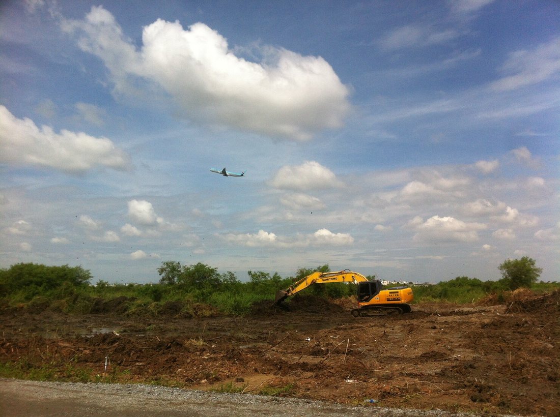 รถขุด Sumitomo ทำงานปรับพื้นที่โครงการสุวรรณภูมิเฟส 2 มองเห็นเครื่องบินบินผ่านด้านบน