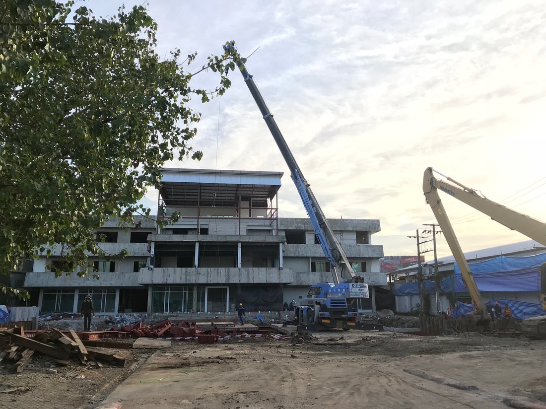 เครนล้อยาง BIG MACHINE TRADING กางบูมเต็มที่ทำงานที่ไซต์ก่อสร้างสำนักงานเศรษฐกิจและวัฒนธรรมไทเป เห็นรถขุด KOMATSU อีกคันด้านขวา