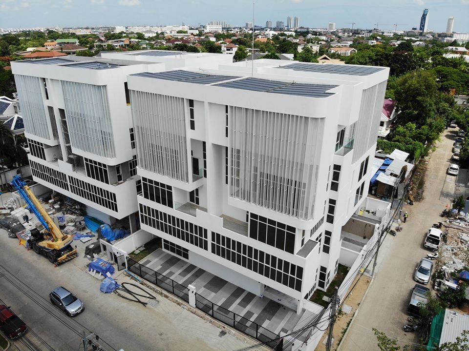อาคาร White Wall ศรีนครินทร์ 57 หลังก่อสร้างแล้วเสร็จ ดีไซน์ผนังกระจกและระแนงทันสมัย เห็นเครนจอดข้างอาคาร